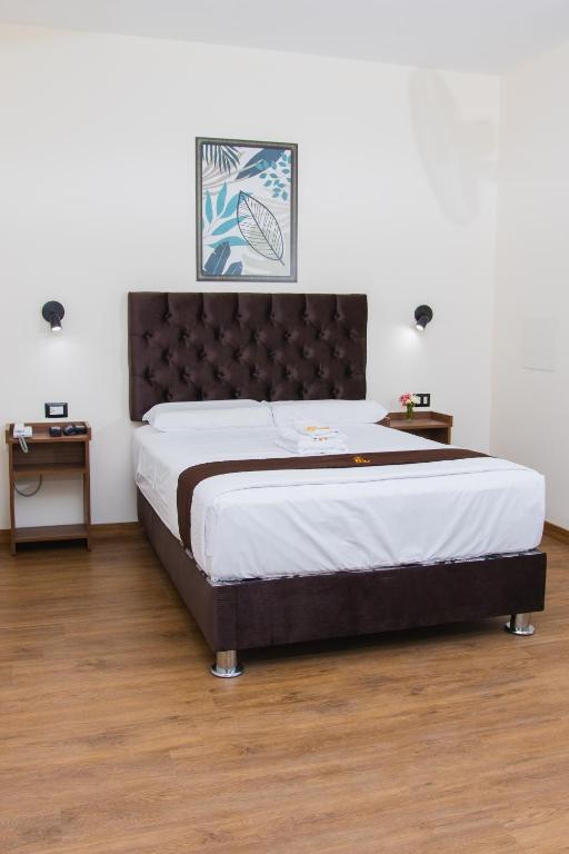 a bedroom with a large bed with a black headboard at Zentra Plaza Hotel & Cowork in Chiclayo