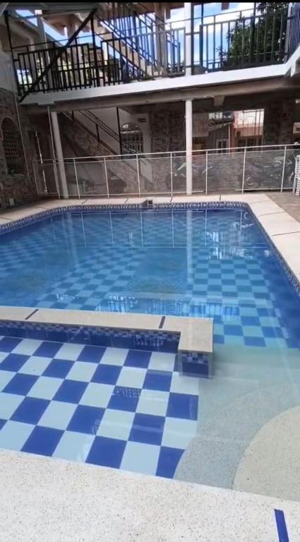 a large swimming pool with a blue and white checkered floor at Hotel El Escorpión in Melgar