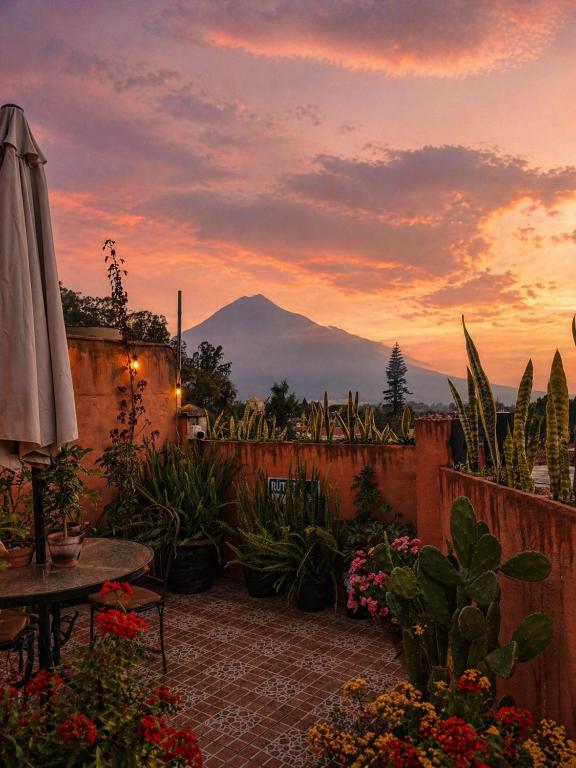 a patio with a table and a view of a mountain at Mazaryk Bed and Breakfast in Antigua Guatemala