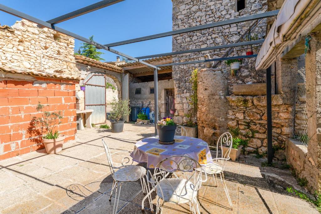 a patio with a table and chairs in a building at L'atelier de Raymond in Verfeuil