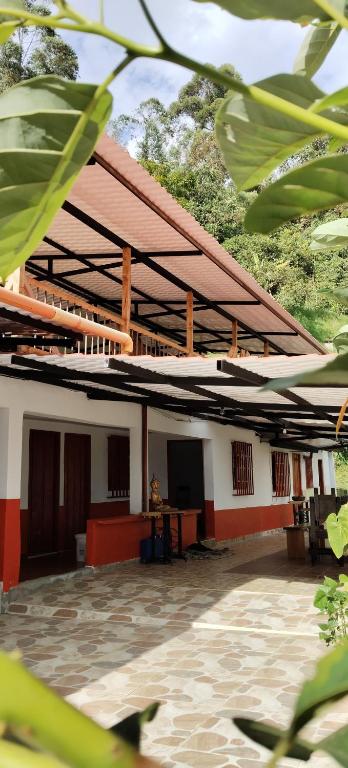 a building with red and white walls and a courtyard at La TOLVA Café & experiencia in Pijao