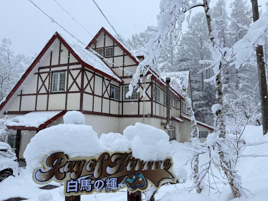 a building covered in snow with a sign in front of it at ray of hakuba 白馬の輝き in Hakuba