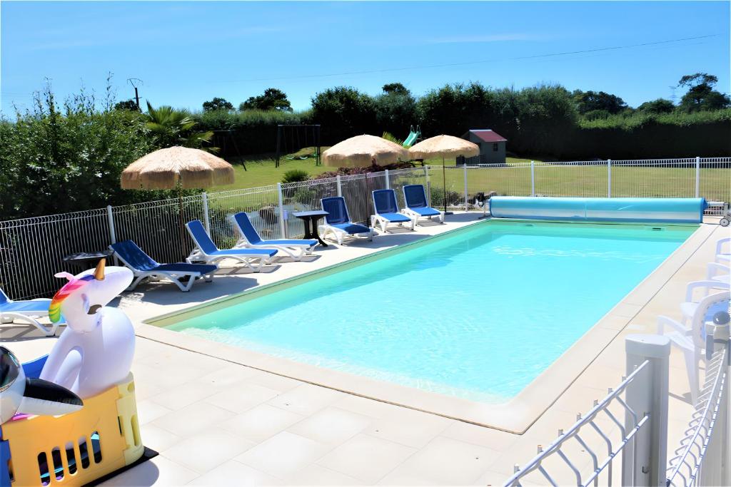 a swimming pool with lounge chairs and a swimming pool at River Cottage - La Mare Chappey in Néhou