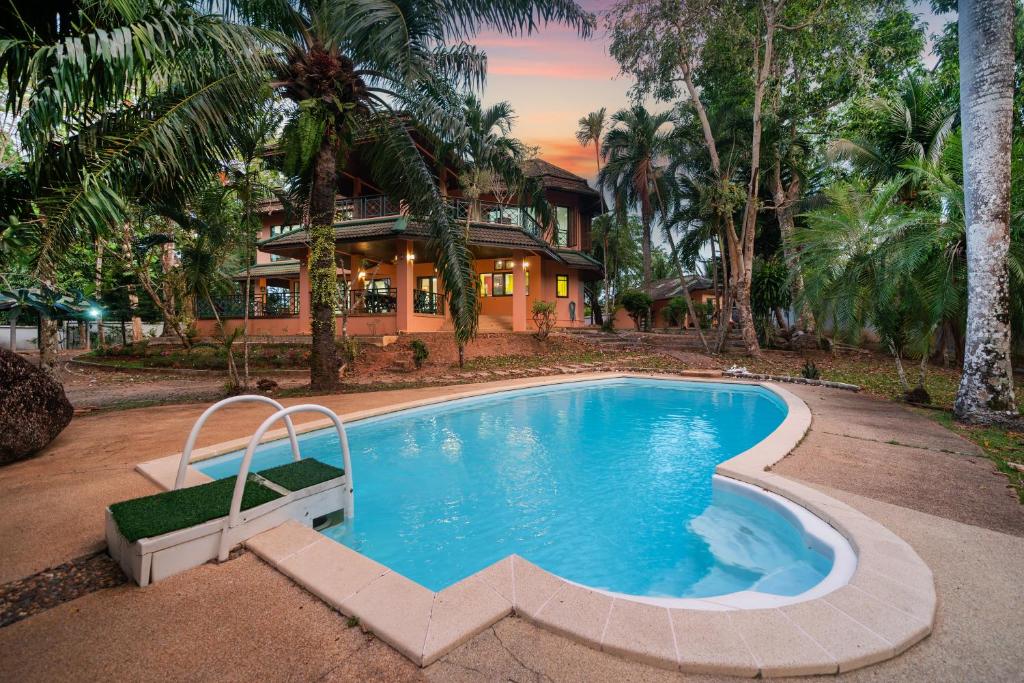 a house with a swimming pool in front of a house at Nature's Hill side Phana House in Phuket