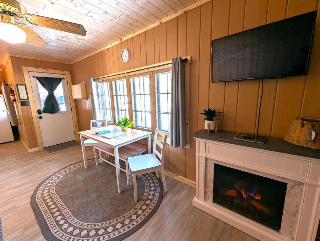 a living room with a table and a fireplace at 2BR 1BA Cabin #2 Riverside Point Resort in Park Rapids