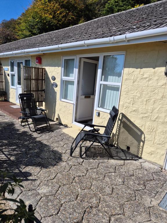two chairs sitting in front of a house at Westcliffe chalets channel view in Niton