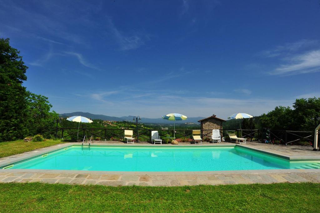 een zwembad in het midden van een tuin bij Torre del Drago in Borgo alla Collina