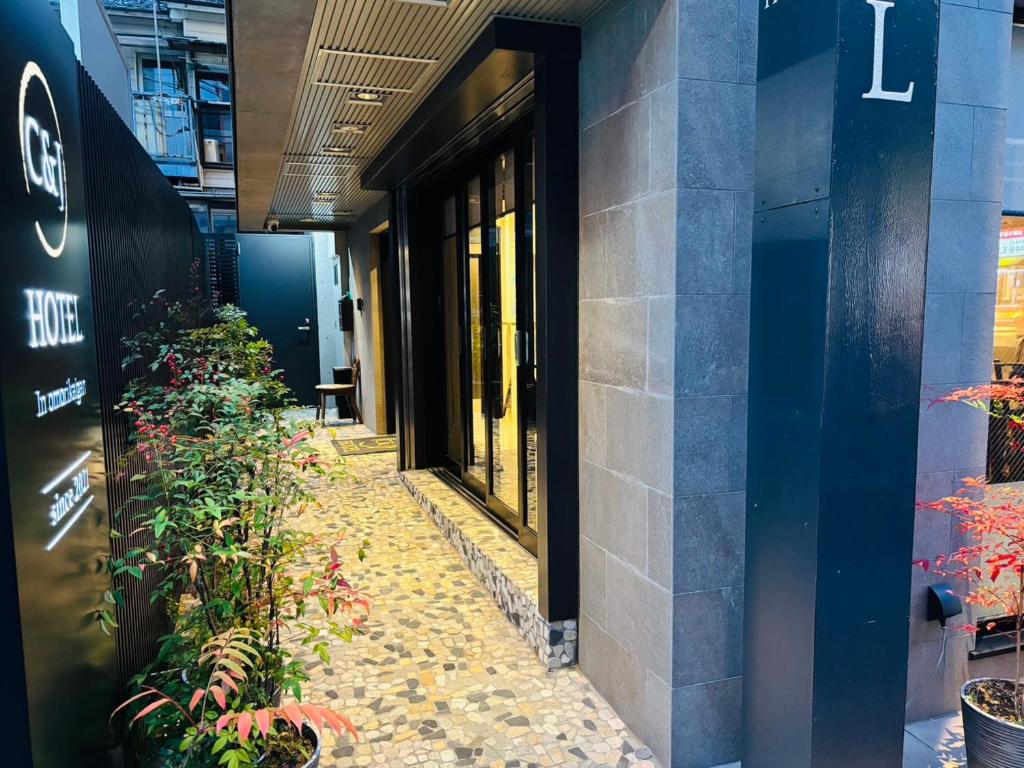 a walkway in front of a building with plants at C＆Jホテル in Tokyo
