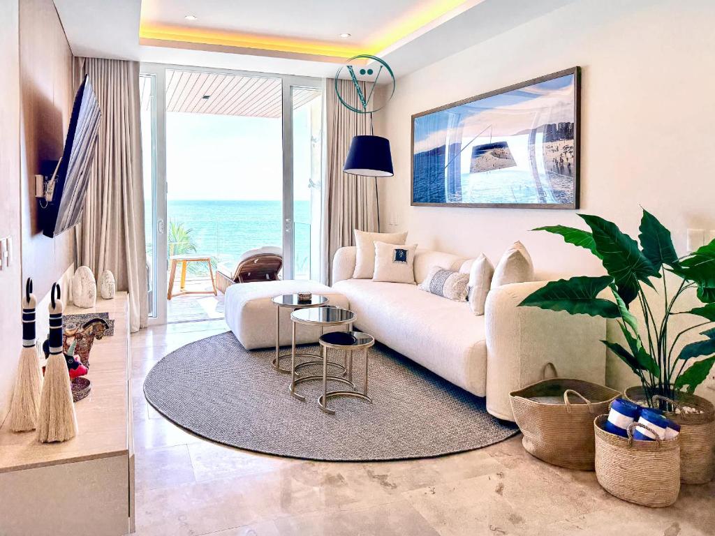 a living room with a white couch and a table at Hear the Waves Luxury Oceanfront Escape in Bucerías