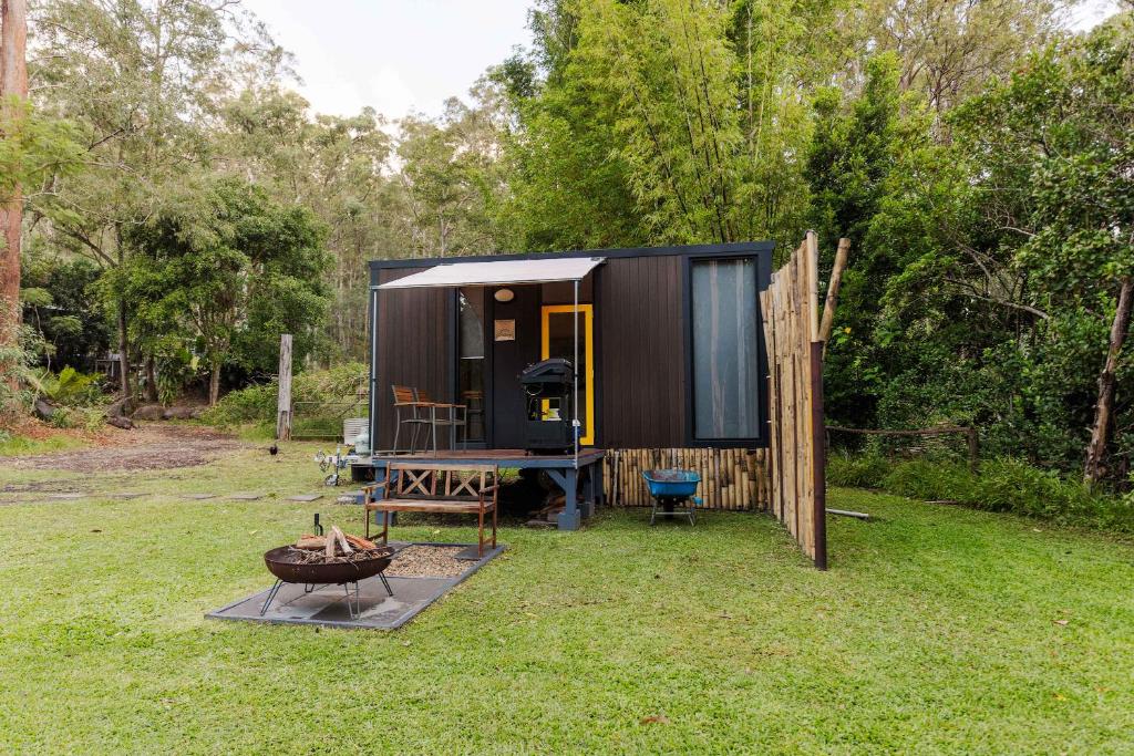 a black tiny house sitting in a yard at Cedar Creek Falls by Tiny Away in Mount Tamborine
