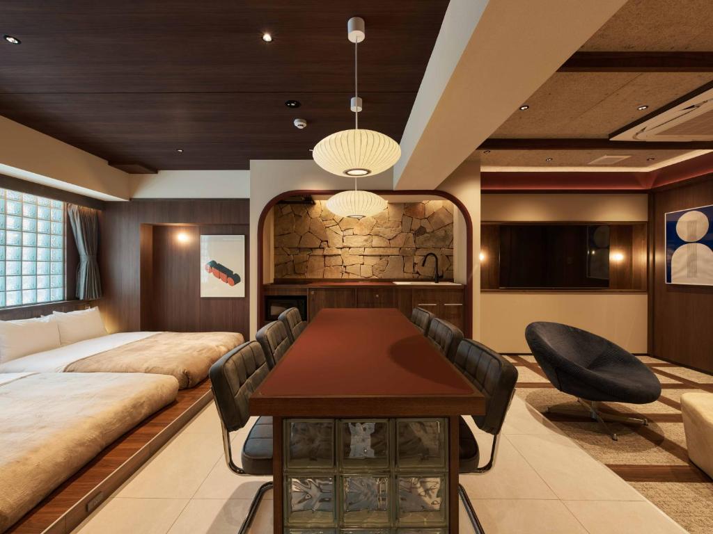 a living room with a bed and a table and chairs at illi Atra Aoyama in Tokyo