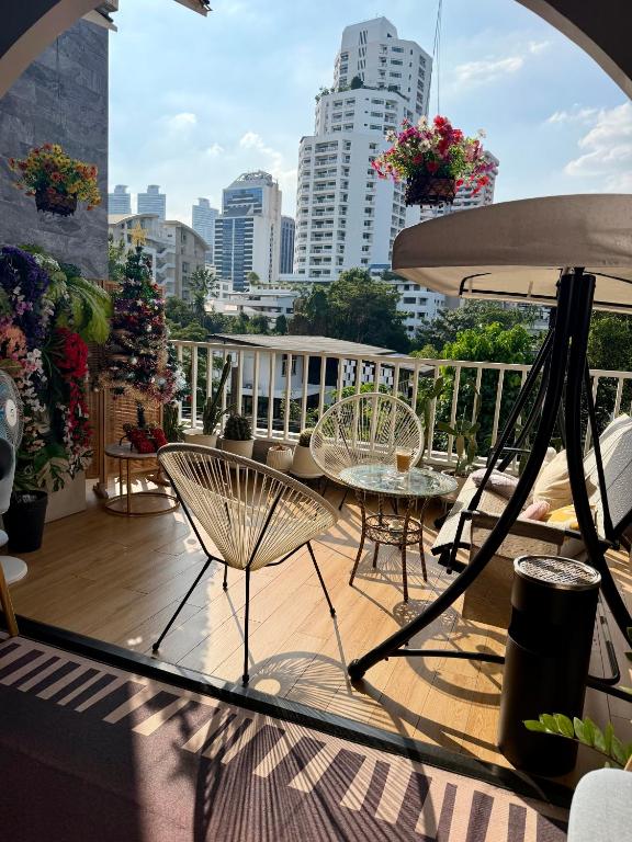 a balcony with a table and chairs and a city at Shizuka House - 500 m walk to BTS Phrom Phong in Bangkok