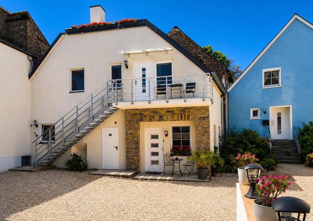 a large white house with a staircase at Ferienwohnung an der Dhron in Neumagen-Dhron
