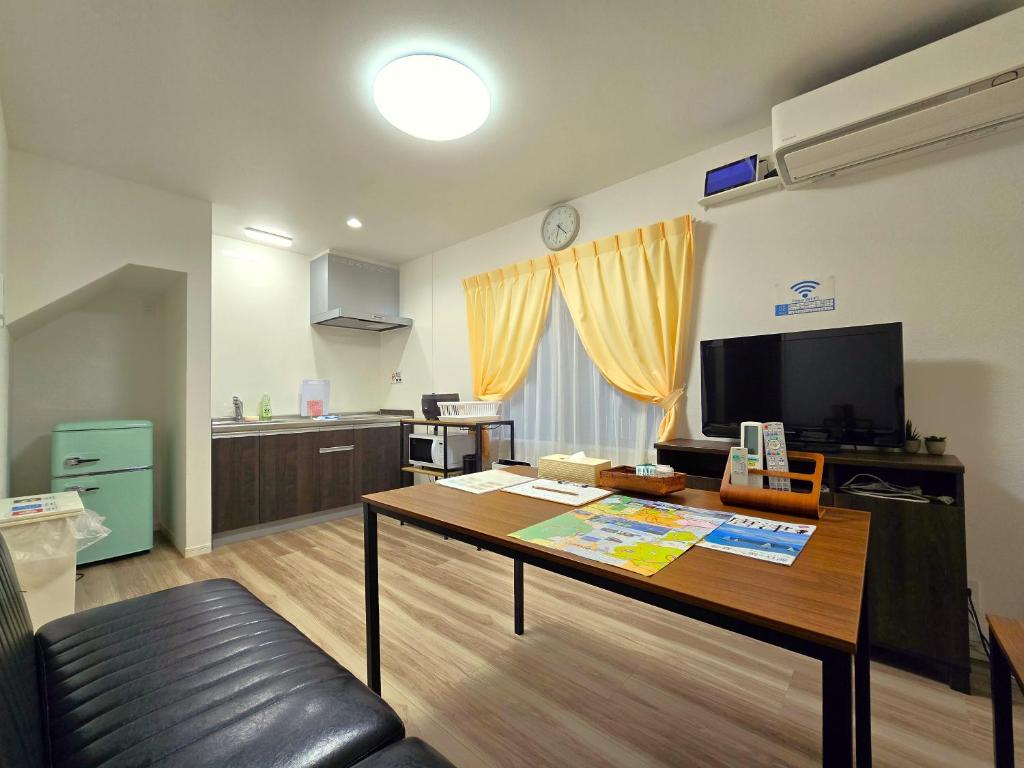 a living room with a table and a kitchen at 鶴城丸（KAKUJYOMARU） in Karatsu