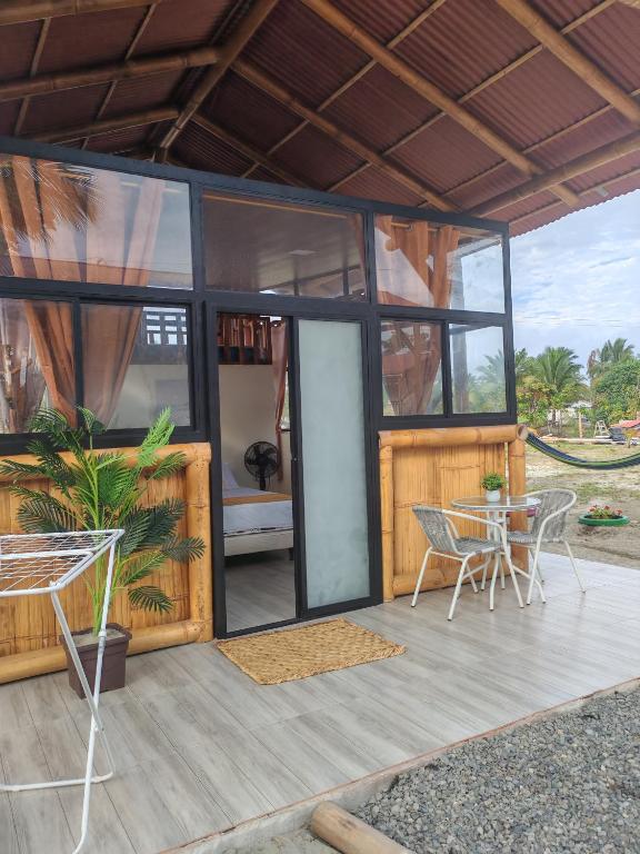 a small house with a table and chairs on a deck at Glampings Boreal in Mompiche
