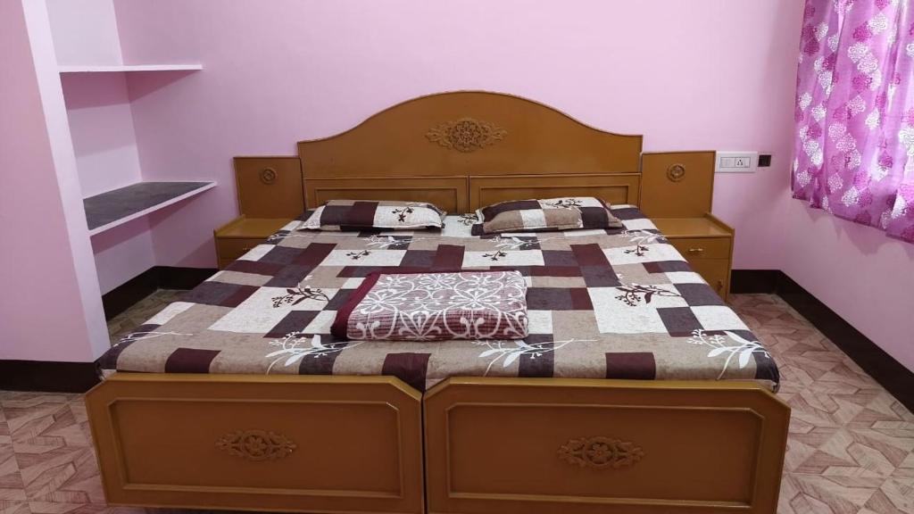 a bed with a wooden headboard in a bedroom at Silver holidays in Yercaud