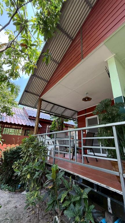a porch of a house with awning on it at Pink Kangaroo Bungalows in Ko Kood