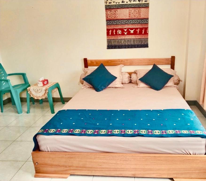 a bedroom with a wooden bed with blue pillows at Homestay Possere in Sadang