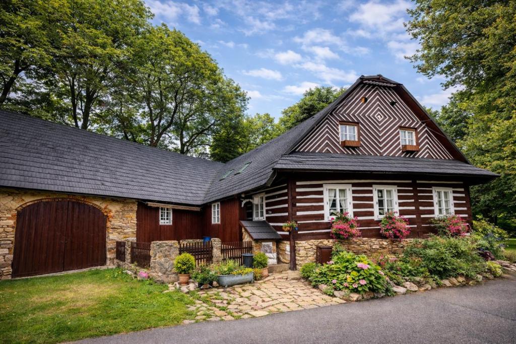 a wooden house with a gambrel roof at Wellness Roubenka u Obory in Svratouch