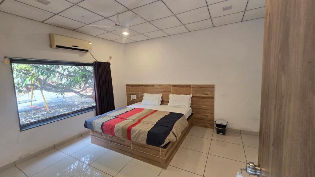 a bedroom with a bed and a large window at Hotel Saffron Indian Spice Resort in Chitrāwal