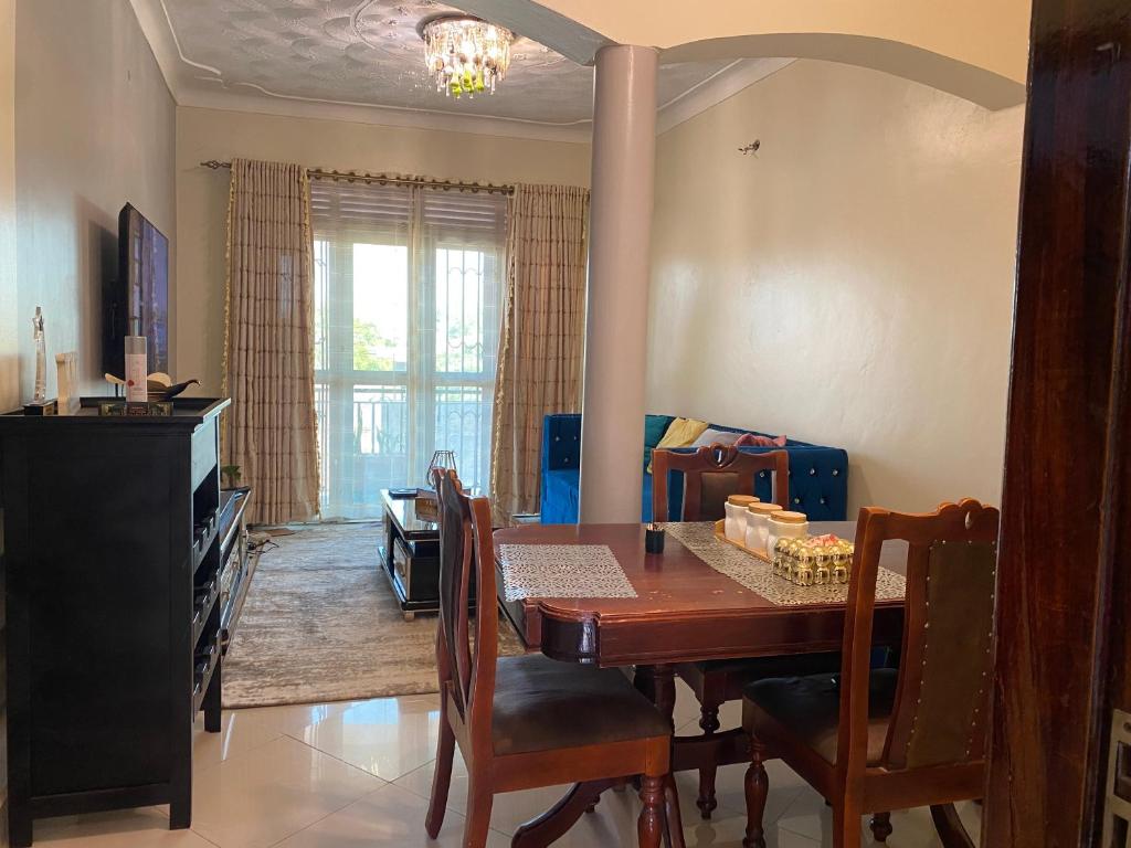 a dining room with a table and chairs and a living room at Private Home in Bugiri