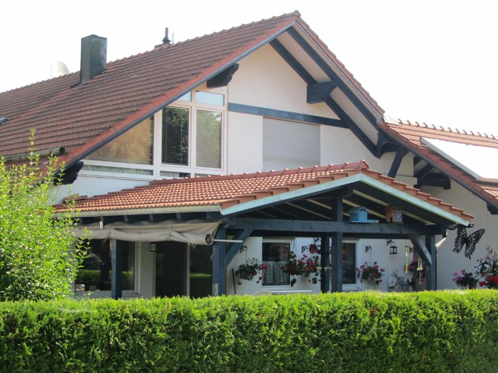 una casa con techo de baldosa y arbustos en Ferienwohnungen Fuchshuber, en Neukirchen vorm Wald