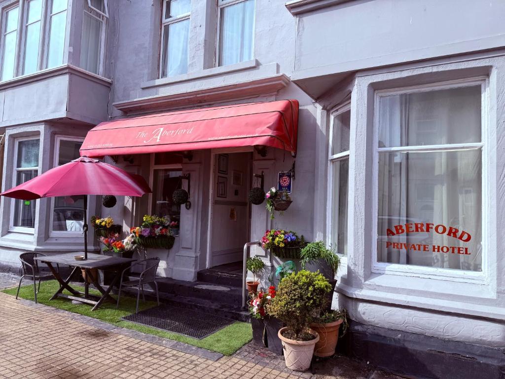 a restaurant with a table and a red umbrella at The Aberford in Blackpool