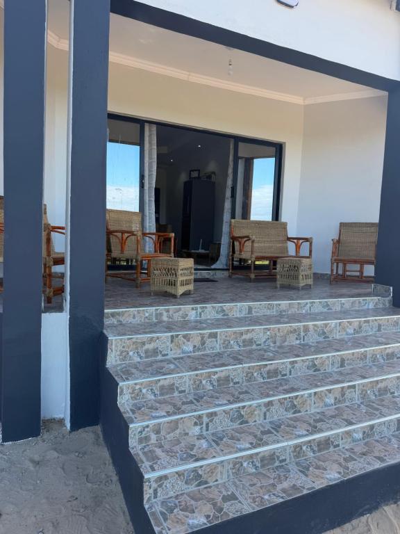 a patio with stairs and chairs on a house at Hilltop Villa Sengabay in Salima