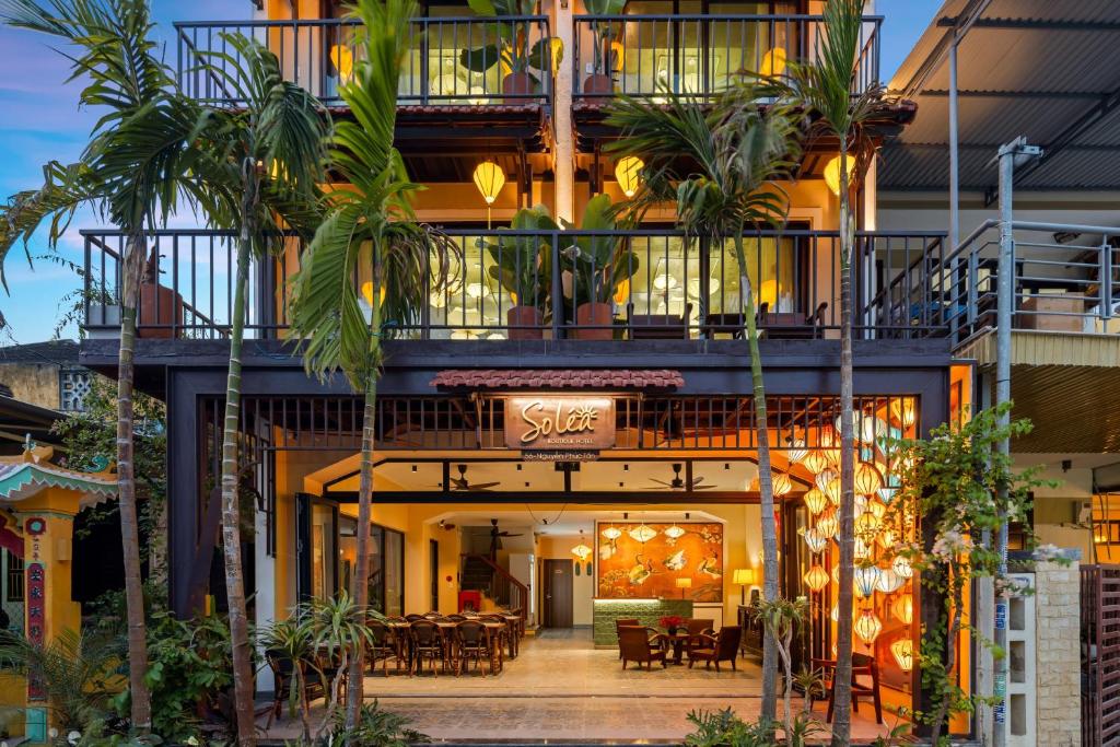 an apartment building with a balcony with a restaurant at Solea Boutique Hoi An - Grand Opening April 2026 in Hoi An