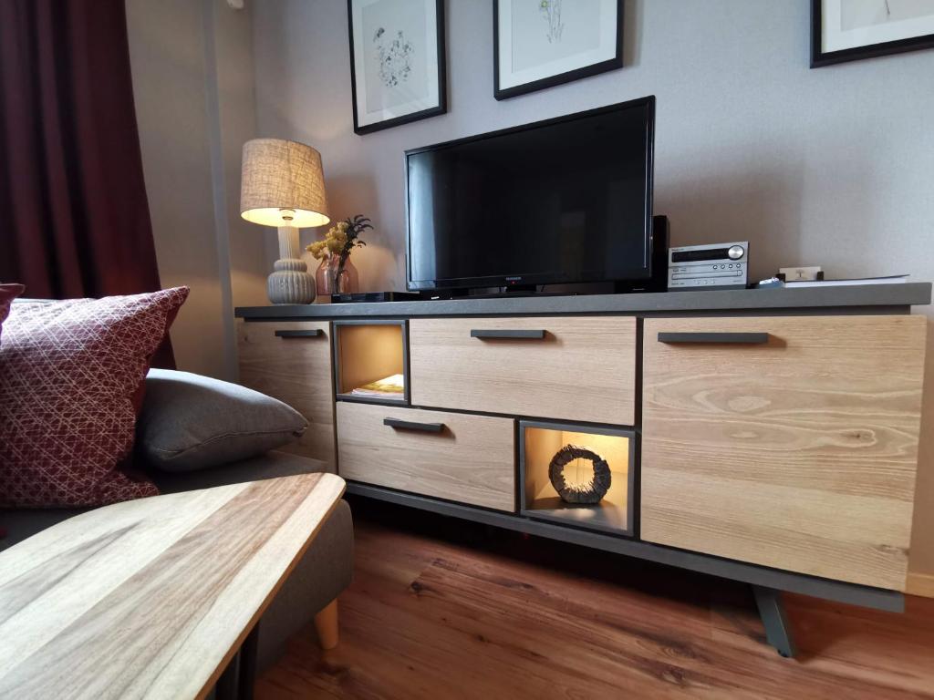a living room with a dresser with a television on it at Ferienwohnung Oliver in Fritzlar