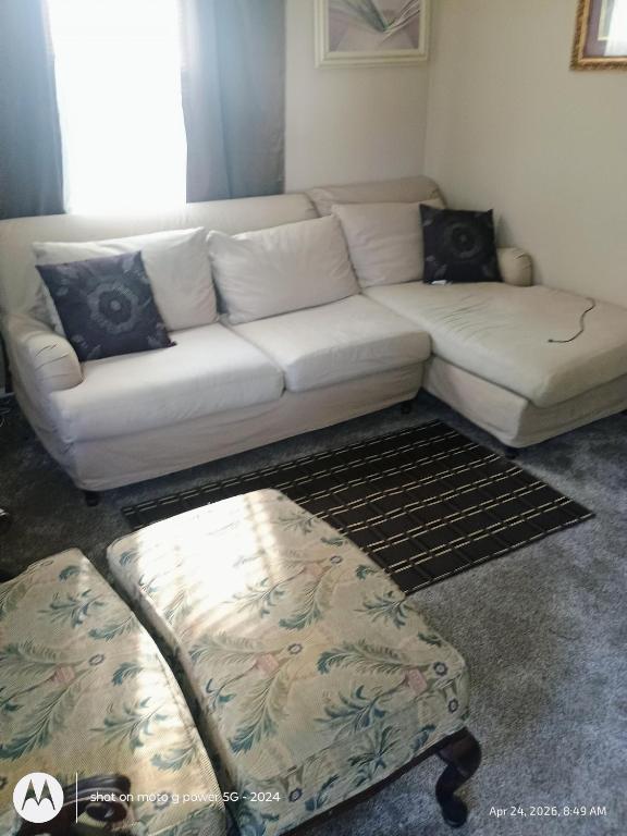 a living room with a white couch and a ottoman at open arms in Elizabeth City