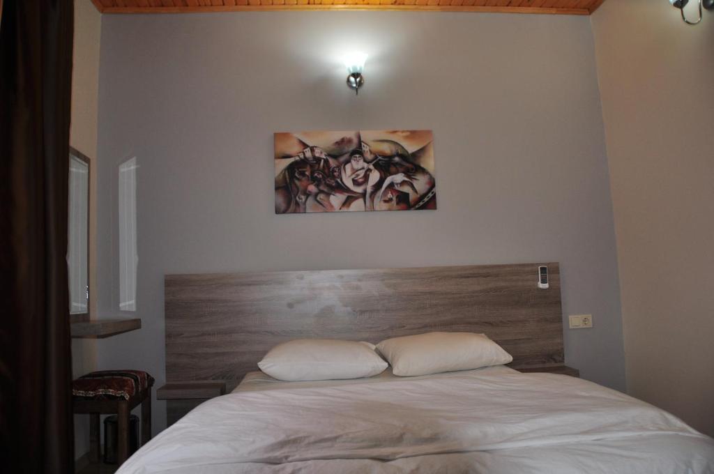 a bed in a bedroom with a picture on the wall at SunAnatolia Otel in Antalya