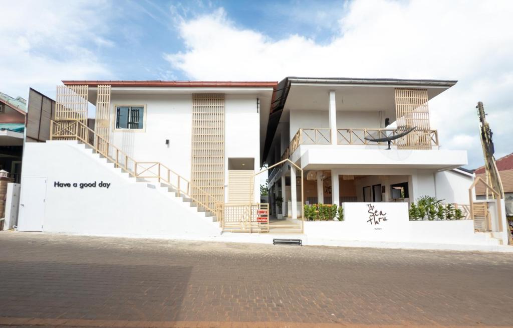 a white house with a staircase in front of it at The Seathru Koh Larn in Pattaya