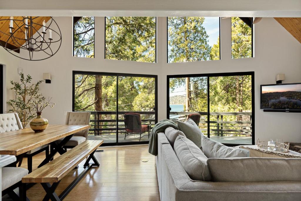 a living room with a couch and a table and windows at The Arrowhead Pearl in Lake Arrowhead
