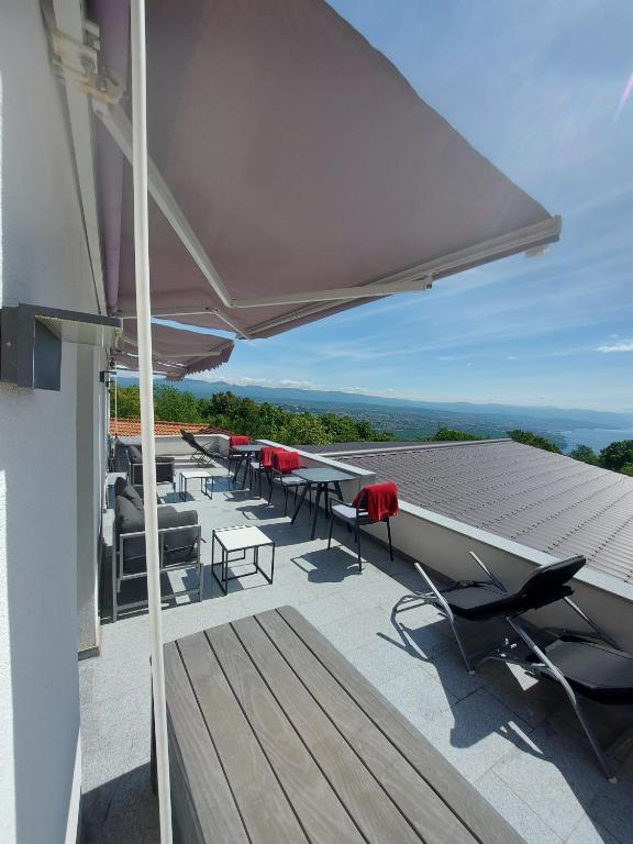a group of tables and chairs on a roof at Panorama House Opatija in Donji Rukavac