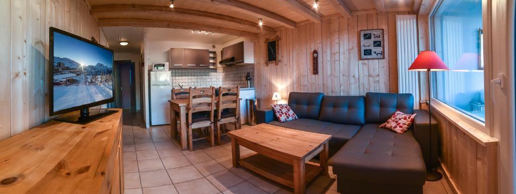 a living room with a couch and a table and a kitchen at Immeuble le Champsaur in Orcières