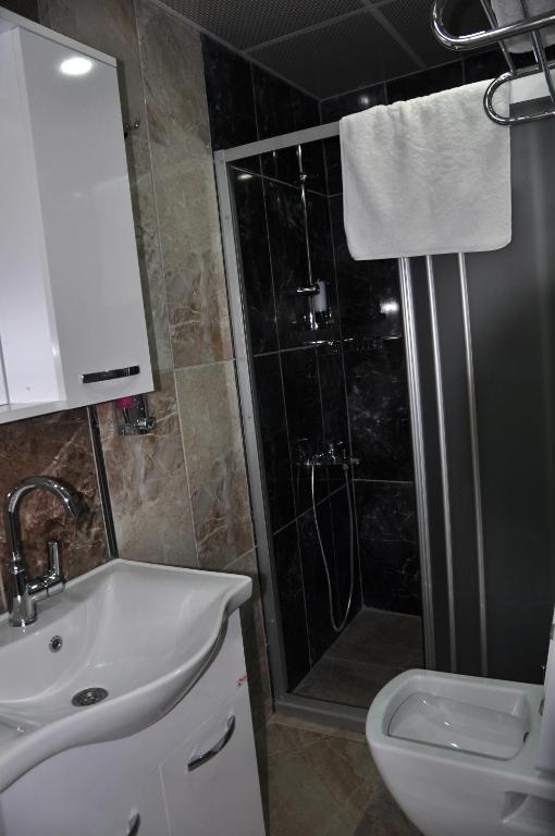 a bathroom with a shower and a sink and a toilet at SunAnatolia Otel in Antalya