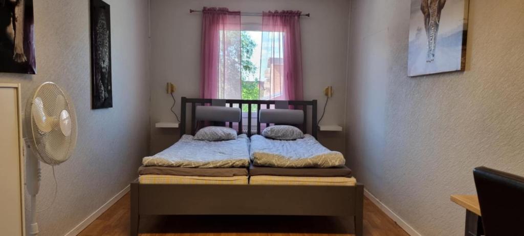 ein kleines Schlafzimmer mit einem Bett und einem Fenster in der Unterkunft Station 14 in Arvidsjaur