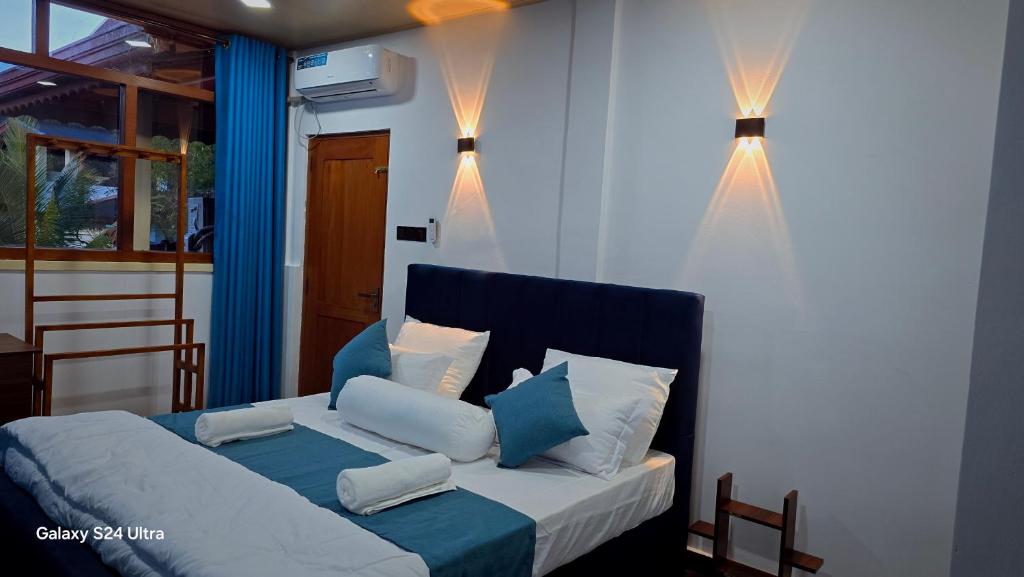 a bedroom with a bed with blue and white pillows at Nature View Villa in Badulla