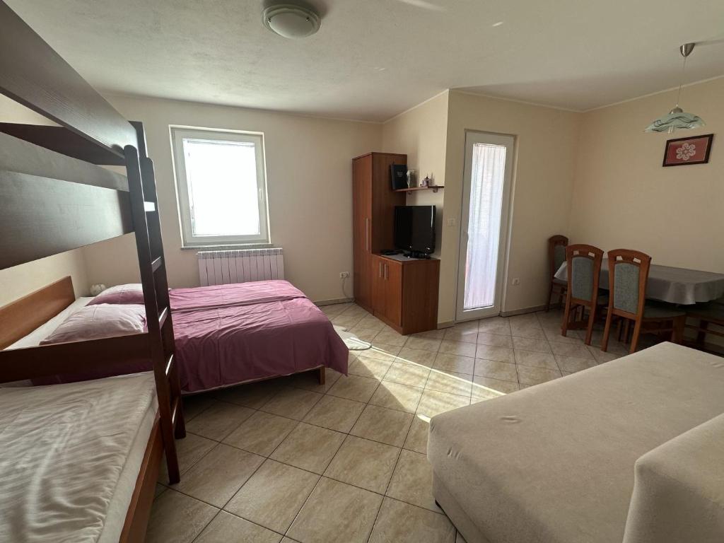 a bedroom with two beds and a table and a kitchen at Tourist Farm Robivera in Šmarje