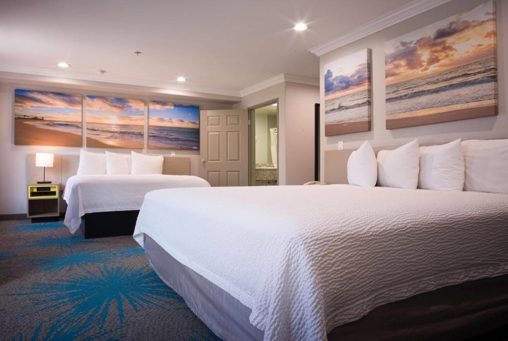 a hotel room with two beds and two paintings on the wall at Days Inn by Wyndham Santa Monica in Los Angeles