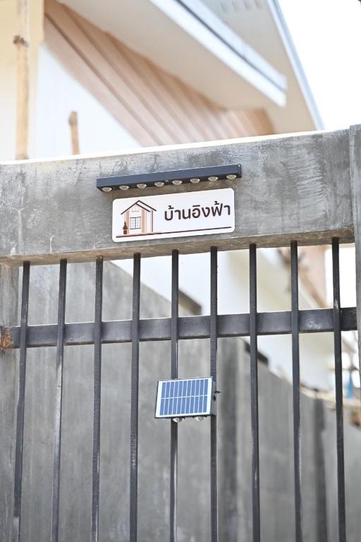 a sign on a fence with a house on it at บ้านอิงฟ้าแม่ฮ่องสอน in Ban Mai Ngae