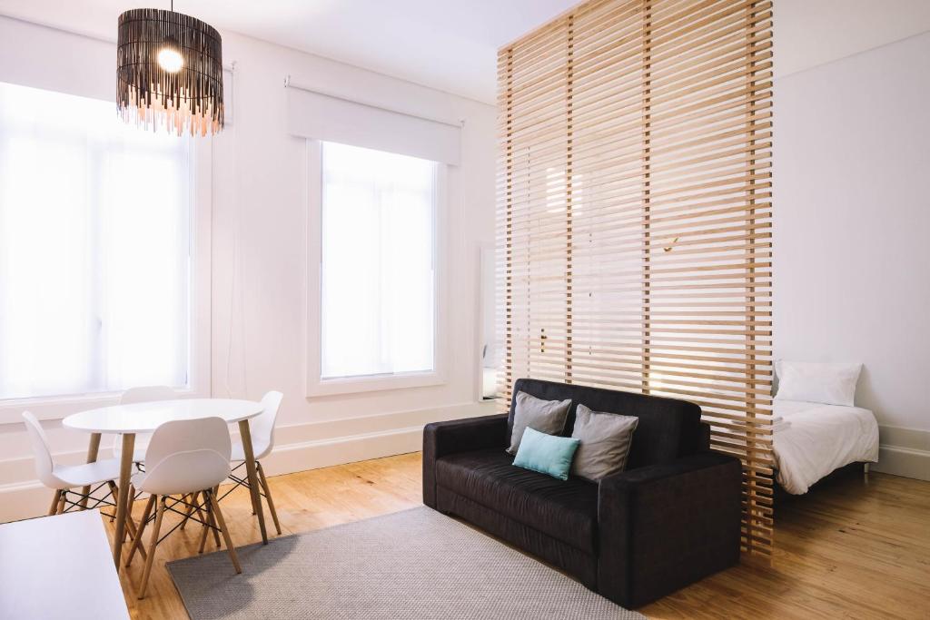 a living room with a black couch and a table at ORM - Ferreira Borges Apartment in Porto