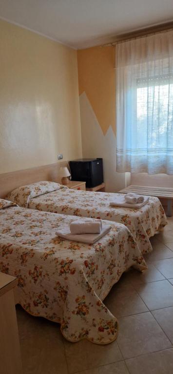 a hotel room with two beds with towels on them at B&B Casa Mia in Alghero