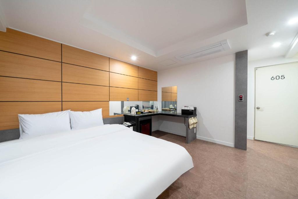 a bedroom with a large bed and a desk in it at Busan Gwangalli Nuri Hotel in Busan