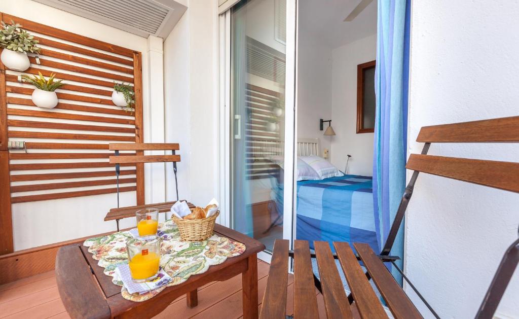 a table with two glasses of orange juice on a balcony at Hola Sitges Apartments in Sitges