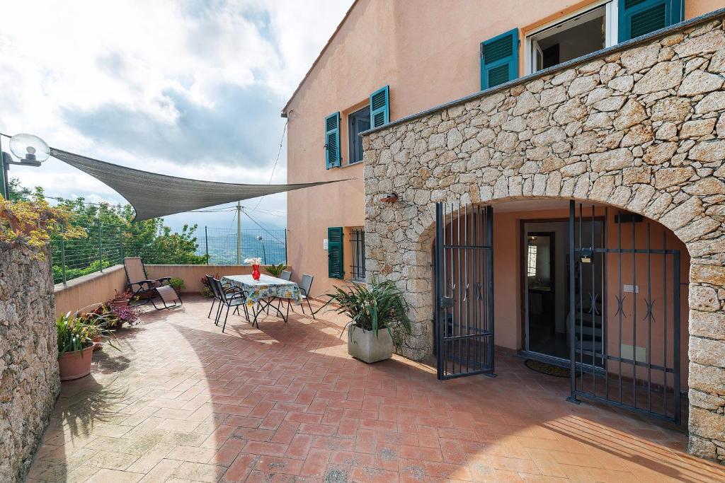 a patio of a building with a table and chairs at Casa Vacanze Il Primo Sole in Finale Ligure