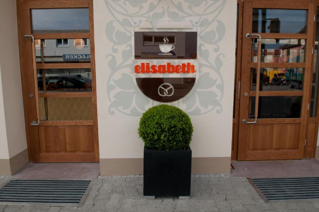 ein Gebäude mit zwei Türen und einer Topfpflanze in der Unterkunft Cafe Elisabeth in Mutterstadt