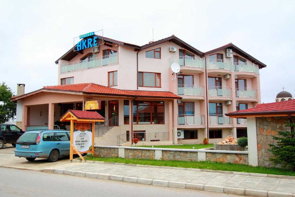 a building with a car parked in front of it at Hotel Akre in Kavarna