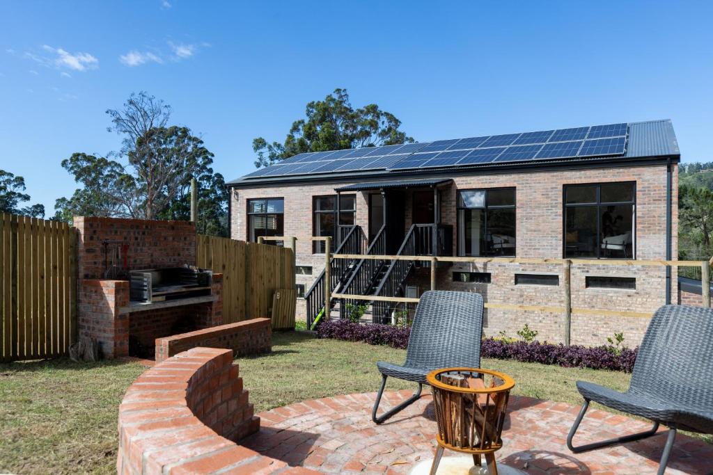 a backyard with a house with solar panels on it at Cape Dutch Stay, Suite B in Sedgefield